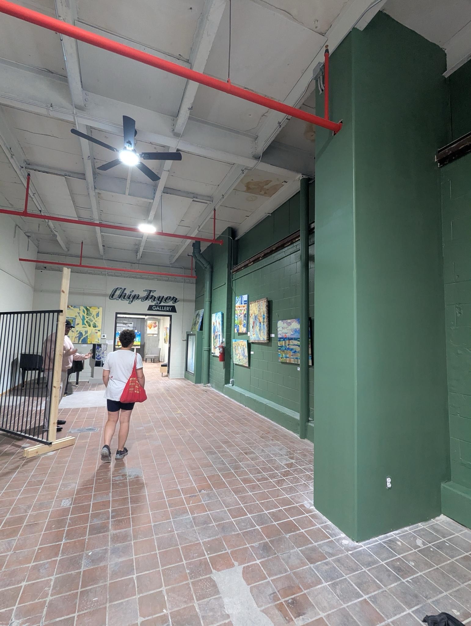 A photo showing an individual standing in the middle of the Chip Fryer Gallery at Clover24